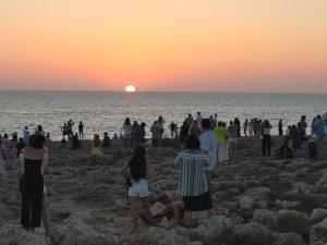 卡兰博希Apartamento Bellavista的一群人在海滩上观看日落
