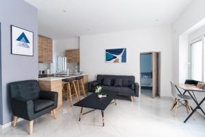 雅典Aiolos luxury suite 3 agios dimitrios center的客厅配有两把椅子和一张桌子