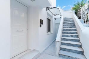 雅典Aiolos luxury suite 3 agios dimitrios center的通往白色建筑的楼梯,有白色的门