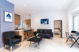 雅典Aiolos luxury suite 3 agios dimitrios center的一间带两张沙发的客厅和一间厨房