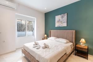 雅典Aiolos luxury suite 3 agios dimitrios center的一间卧室配有一张带两个枕头的床