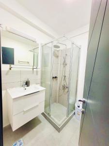 曼加利亚Laguna Grey的一间带玻璃淋浴和水槽的浴室