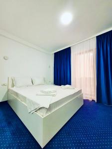 曼加利亚Laguna Grey的一间卧室设有一张大床,铺有蓝色的地板