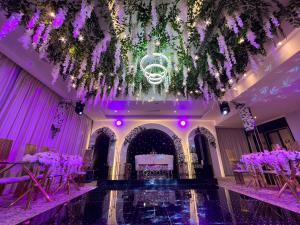 安曼Kaya Hotel Amman的一个带紫色花卉和桌子的婚礼大厅