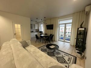 罗夫诺Soborna Apartment的客厅配有白色的沙发和桌子