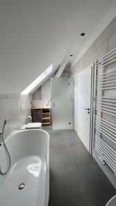 措森New Nomads Ferienwohnung am See的白色的浴室设有浴缸和水槽。