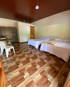 SuchitotoHostal las 3 J的一间卧室设有两张床,铺有木地板