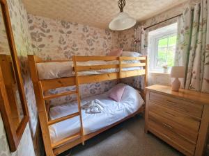 Great SalkeldGarth at Wetheral Cottages的一间卧室配有两张双层床和一张书桌