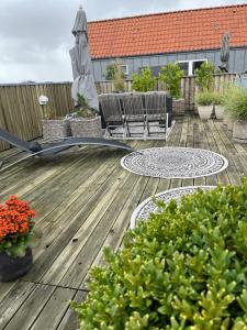 海宁Skøn centralt beliggende lejlighed m.tagterrasse的木制甲板上配有椅子和遮阳伞的庭院