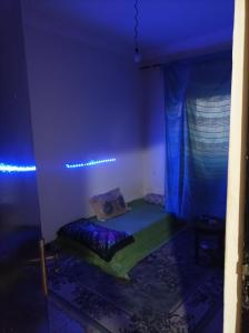 卡萨布兰卡Ain sbaa Hay mohmmadi的一间蓝色灯的房间,配有一张床铺