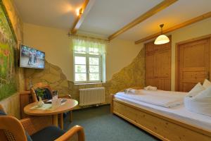萨克森自由州诺伊斯塔滕Gasthof Ungerberg的一间卧室配有一张床、一张桌子和一台电视。