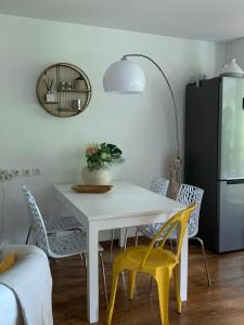 布里德莱班Entre Neige et Thermes的一间设有白色桌子和黄色椅子的用餐室