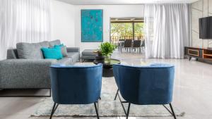 埃拉特By Eezy - אורה דירות אירוח的客厅配有蓝色椅子和沙发