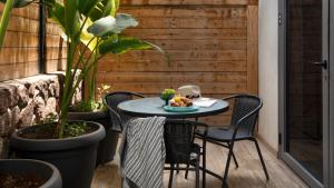埃拉特By Eezy - אורה דירות אירוח的种有植物的庭院里的桌椅