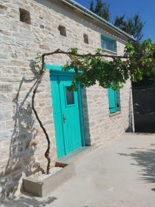 拉夫科斯Nectar的一座砖砌的建筑,有一扇蓝色的门和一棵树