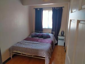 多尼戈尔19 Doran Close的一间卧室配有一张带紫色枕头的床和窗户。