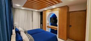 拉巴特RABAT RESIDENCE - rooms & aparts的一间卧室配有蓝色的床和电视