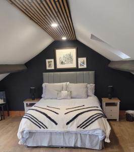 MynffordSnowdon view, steam railway & Portmeirion nearby的一间卧室设有一张大床和黑色的墙壁