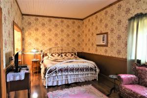 马里波萨玛丽珀撒客栈酒店的一间卧室配有一张床和一把椅子
