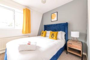布里斯托Centralised Temple Wall - Contractors, Families - FREE PARKING by Prescott Apartments的卧室配有蓝色和白色的床以及黄色枕头