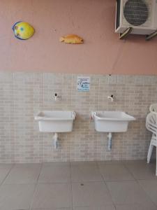 弗洛里亚诺波利斯Residêncial Rosa的浴室设有两个水槽,墙上有一条鱼