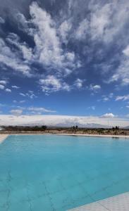 AgreloVillas Del Malbec Lodges的海滩前的蓝色海水游泳池