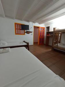 贾丁Hosteria El Paraiso的一间卧室配有一张床,另一间卧室配有红色的门