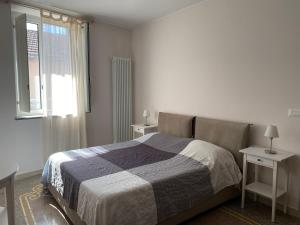 维拉诺瓦达尔本加Case Rossa e Blu的一间卧室设有床、两张桌子和一扇窗户