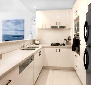 黄金海岸Southport Sea Views - Shores Apartment的白色的厨房配有白色橱柜和水槽