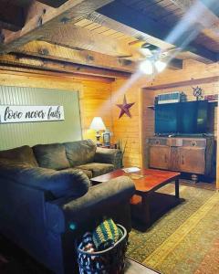 尤里卡斯普林斯3 Bedroom log cabin with hot tub at Bear Mountain的客厅配有沙发和桌子