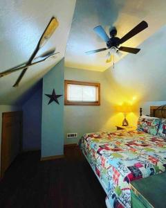尤里卡斯普林斯3 Bedroom log cabin with hot tub at Bear Mountain的一间卧室配有吊扇和一张床