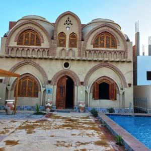 卢克索Mystical habou domes villa的一座建筑前面设有游泳池