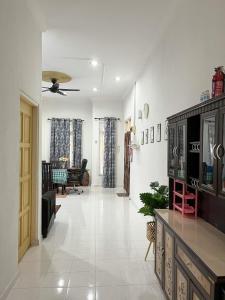 Homestay Seri Aman Pasir Puteh的带沙发和吊扇的客厅