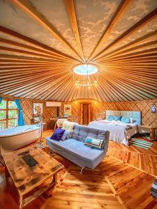 圣若阿金Solar do Oriente - Yurt Ecovillage的一间卧室配有一张床、一张沙发和一张桌子