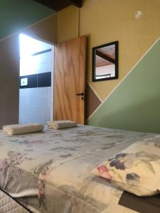 乌拉圭河畔康塞普西翁Hostal - Sueños del Rio的一间卧室设有一张大床、窗户和门