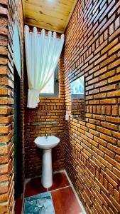 Da Let House & Coffee的砖墙内带白色水槽的浴室