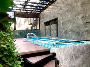 下龙湾BBQ Hostel Ha Long 2的一座大楼内带热水浴池的游泳池