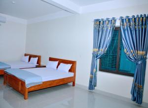 荣市Vinh Airport Hotel的一间卧室设有两张床和窗户。