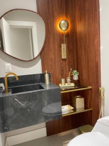 伊塔佩马Apart moderno 3 suites 2 vagas de garagem e quadra do mar的一间带水槽和镜子的浴室
