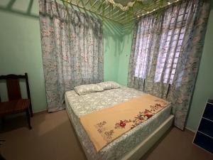 哥打巴鲁Raudah Homestay的一张小床,位于带窗帘和西德西德床的房间