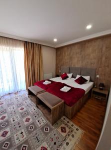 梅斯蒂亚梅斯蒂亚山酒店的一间卧室配有一张带红色枕头的大床