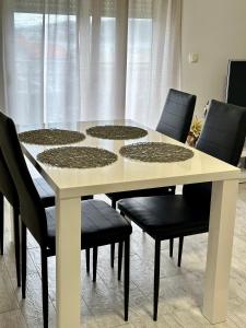 Kaštel SućuracApartman Nela的周围设有一张白色桌子和黑色椅子