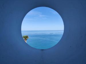 皮佐B&B Casa Angelieri的透过圆形窗户欣赏海景