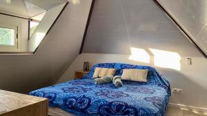 普纳奥亚Vanakea Beach House的一间卧室配有蓝色的床和两个枕头
