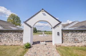 Arklių Pašto Stotis的石墙庭院中的拱门