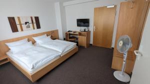 斯图加特齐格勒加特豪斯酒店的一间卧室配有一张床和一张带风扇的书桌
