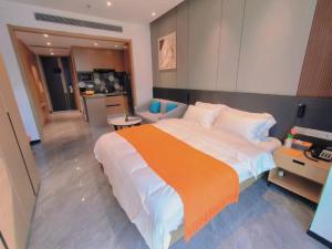 东莞Shi Lai De Executive Apartments的一间卧室配有一张带橙色毯子的大床