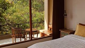 姆杜克Gumi Ayu EcoStay的一间卧室配有一张床和一个带椅子的窗户