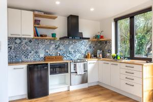 皮克顿Firkins Retreat, Picton的厨房配有白色橱柜和蓝色及白色瓷砖
