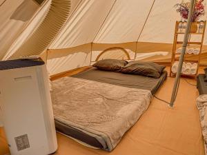 美奈MUINE SUN & SEA BEACH ( BOUTIQUE RESORT & GLAMPING)的房间里的帐篷里的一张床位